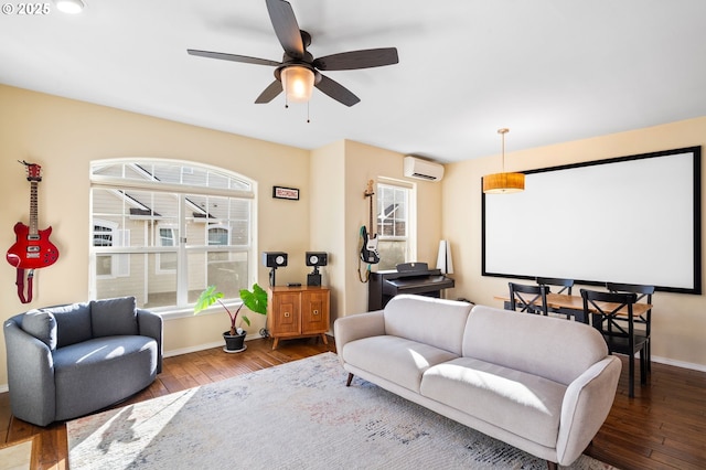 home theater featuring an AC wall unit, a ceiling fan, baseboards, and wood-type flooring