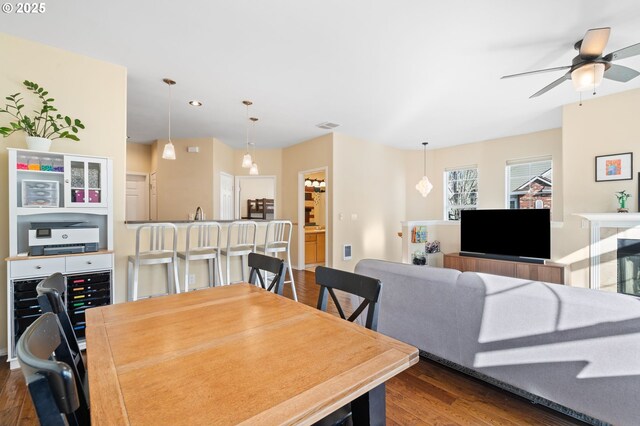 dining space with ceiling fan, dark wood finished floors, and visible vents
