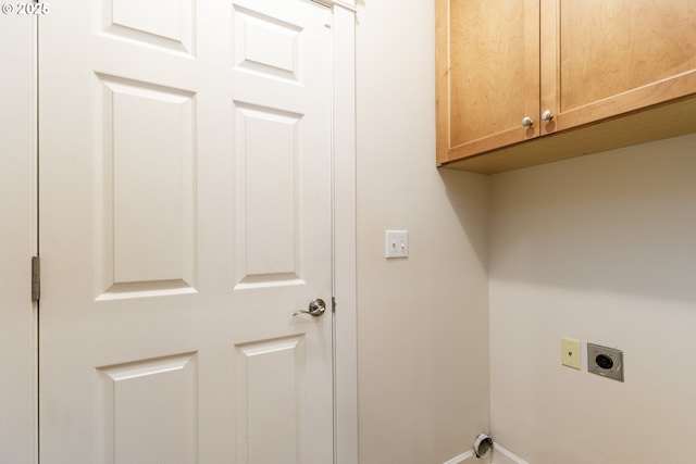 clothes washing area featuring cabinets and hookup for an electric dryer