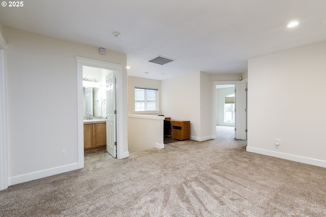 unfurnished living room featuring sink and light colored carpet