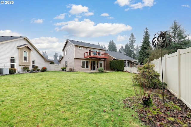 rear view of house featuring a lawn and central AC