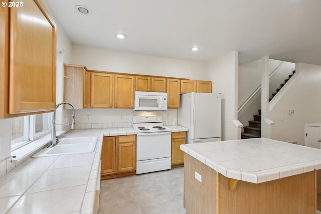 kitchen featuring white appliances, tile counters, sink, and a kitchen island