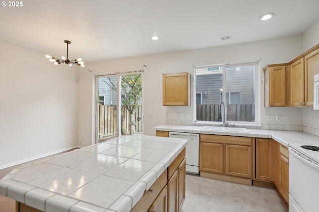 kitchen featuring sink, white appliances, tile counters, decorative light fixtures, and a chandelier