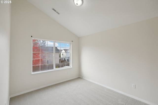 spare room with vaulted ceiling and carpet