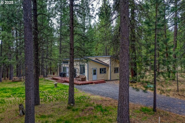 16811 Covina Rd, Bend, OR 97707 - view of front of home featuring a deck, a wooded view, and driveway