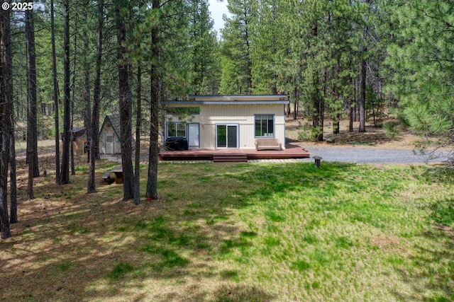 16811 Covina Rd, Bend, OR 97707 - view of front facade with a wooden deck, a front lawn, and a forest view
