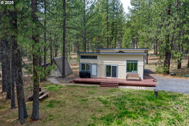 16811 Covina Rd, Bend, OR 97707 - back of house featuring a deck, a yard, a forest view, and an outbuilding