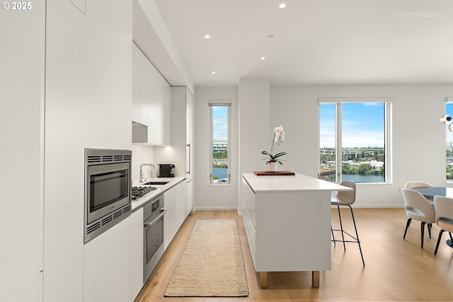 kitchen with modern cabinets, white cabinets, a center island, plenty of natural light, and recessed lighting