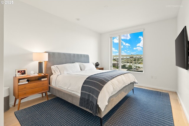 bedroom featuring light wood-style floors and baseboards