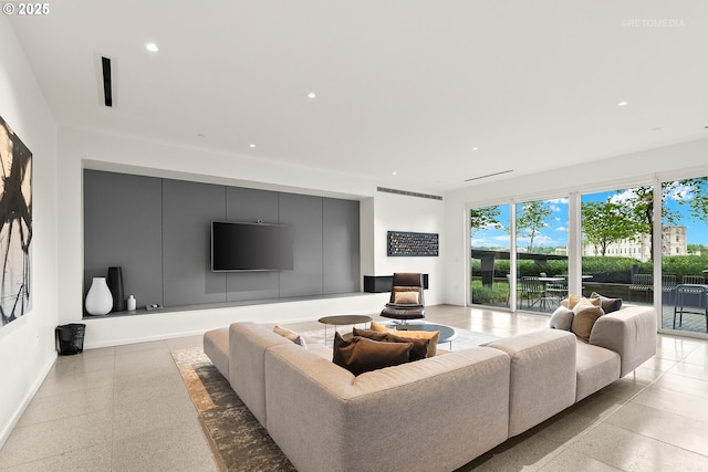 living room featuring dark speckled floor, baseboards, and recessed lighting