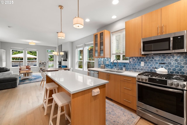 1011 NE 73rd Ave, Portland, OR 97213 - kitchen with stainless steel appliances, open floor plan, a center island, decorative backsplash, and light countertops