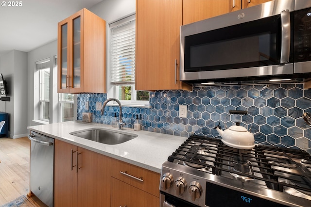 1011 NE 73rd Ave, Portland, OR 97213 - kitchen with appliances with stainless steel finishes, light wood-type flooring, light stone counters, and backsplash