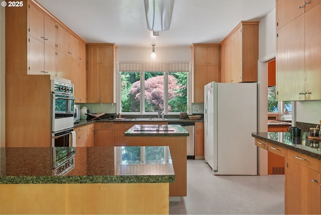 6151 SW Mill St, Portland, OR 97221 - kitchen featuring white fridge with ice dispenser, stainless steel dishwasher, healthy amount of natural light, and dark stone counters