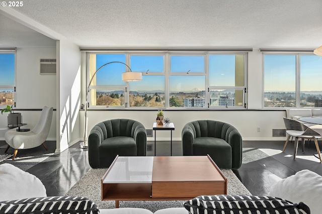 living room featuring a textured ceiling, a wall mounted air conditioner, visible vents, and baseboards