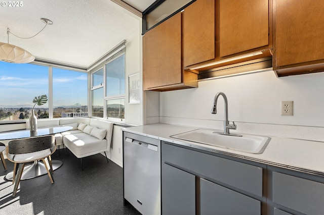 kitchen with dishwasher, light countertops, gray cabinets, and a sink