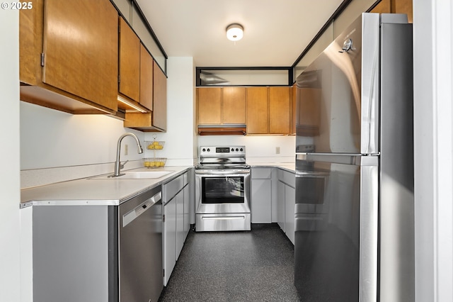 kitchen with under cabinet range hood, a sink, light countertops, appliances with stainless steel finishes, and brown cabinetry