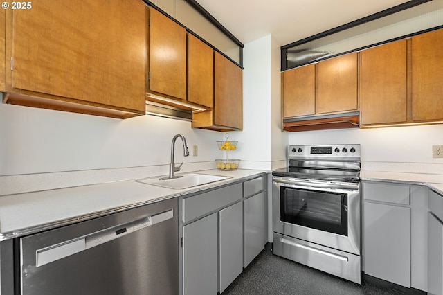 kitchen with stainless steel appliances, light countertops, a sink, and under cabinet range hood