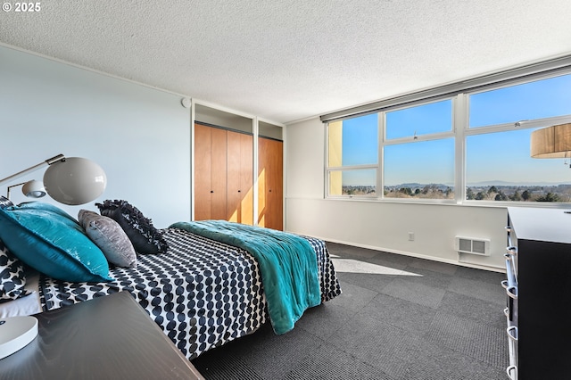 bedroom with visible vents, a textured ceiling, baseboards, and multiple windows