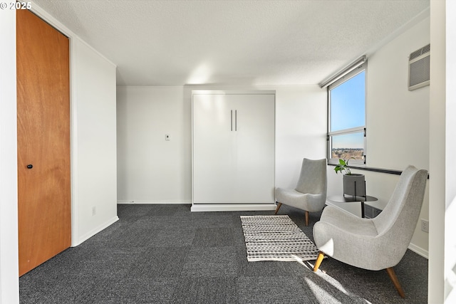 living area featuring carpet floors, baseboards, a textured ceiling, and a wall mounted AC