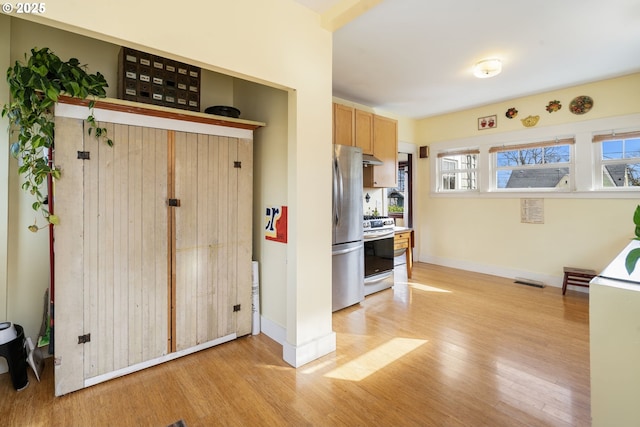 155 S 8th St, Saint Helens, OR 97051 - kitchen with stainless steel appliances, baseboards, light wood-type flooring, under cabinet range hood, and visible vents