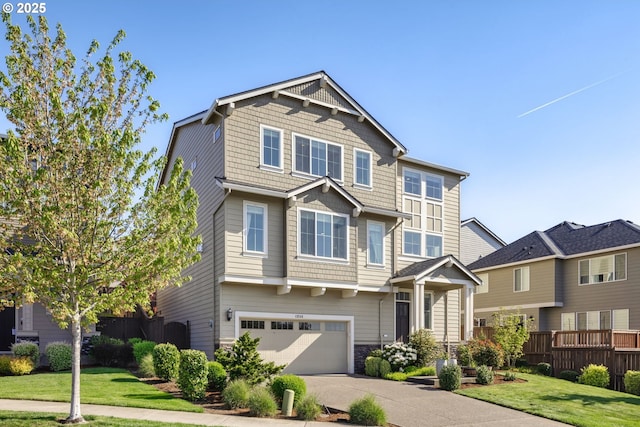 craftsman-style house with concrete driveway, fence, a front yard, and a garage