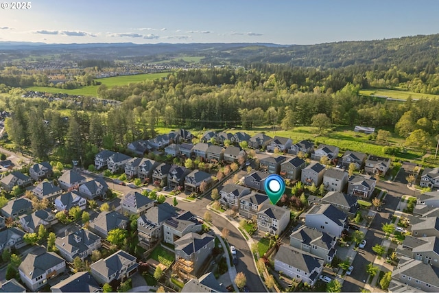 drone / aerial view featuring a residential view and a wooded view