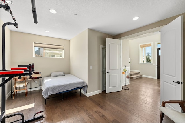 bedroom with baseboards, wood finished floors, and recessed lighting