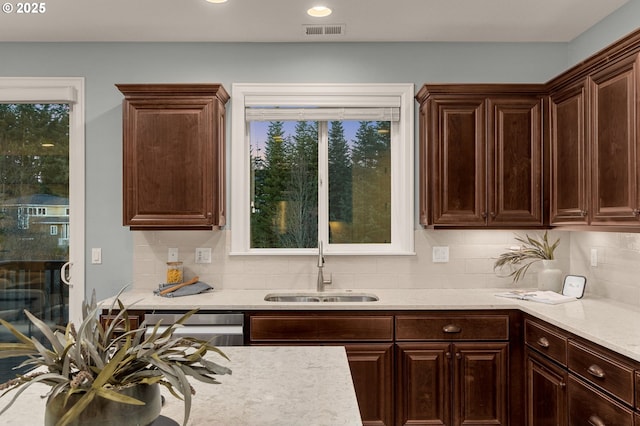 kitchen featuring tasteful backsplash, dark brown cabinets, and sink