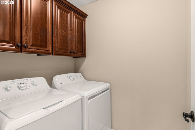 washroom featuring cabinets and independent washer and dryer