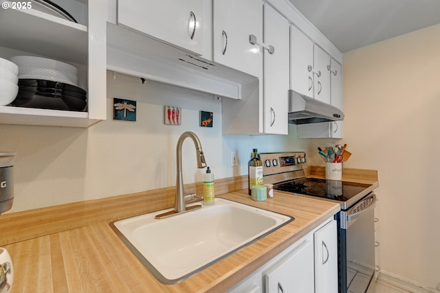 7508 SW Barnes Rd Unit A, Portland, OR 97225 - kitchen with stainless steel electric stove, under cabinet range hood, white cabinets, and light countertops