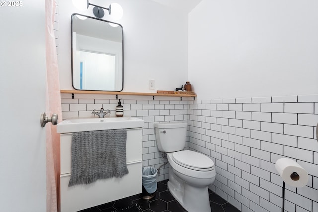 65 SW Frenwood Way, Beaverton, OR 97005 - bathroom with toilet, tile patterned floors, tile walls, and a wainscoted wall