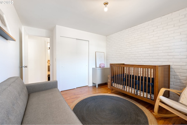65 SW Frenwood Way, Beaverton, OR 97005 - bedroom featuring brick wall, wood finished floors, and a closet