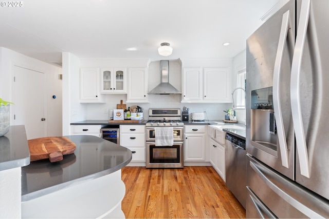 65 SW Frenwood Way, Beaverton, OR 97005 - kitchen featuring appliances with stainless steel finishes, wall chimney range hood, wine cooler, white cabinetry, and recessed lighting