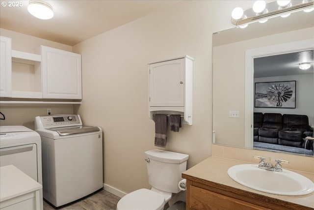 808 SE Beaver Creek Ln, Troutdale, OR 97060 - bathroom featuring washer and clothes dryer, vanity, toilet, wood finished floors, and baseboards