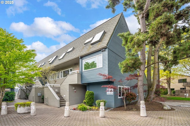 view of front of property with a shingled roof and stairs
