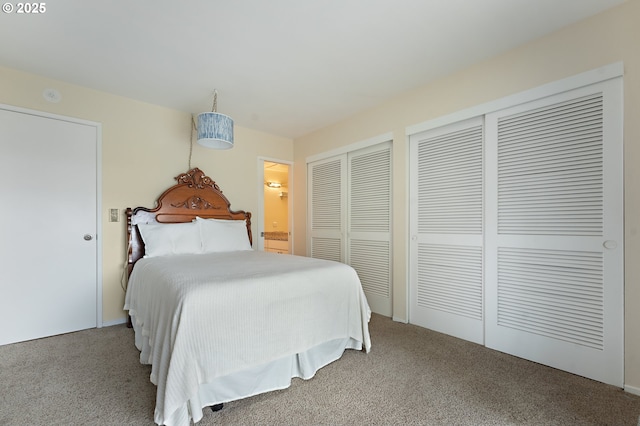 bedroom with connected bathroom, multiple closets, and carpet floors