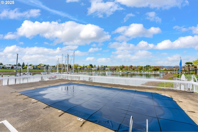 view of swimming pool featuring a water view and fence