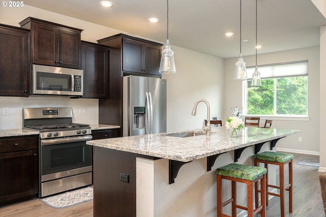 2314 SW 43rd St, Gresham, OR 97080 - kitchen with stainless steel appliances, a kitchen bar, light stone counters, and recessed lighting