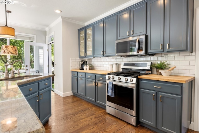 4698 Winthrop Ct, Lake Oswego, OR 97035 - kitchen featuring stainless steel appliances, ornamental molding, butcher block counters, tasteful backsplash, and dark wood-style flooring