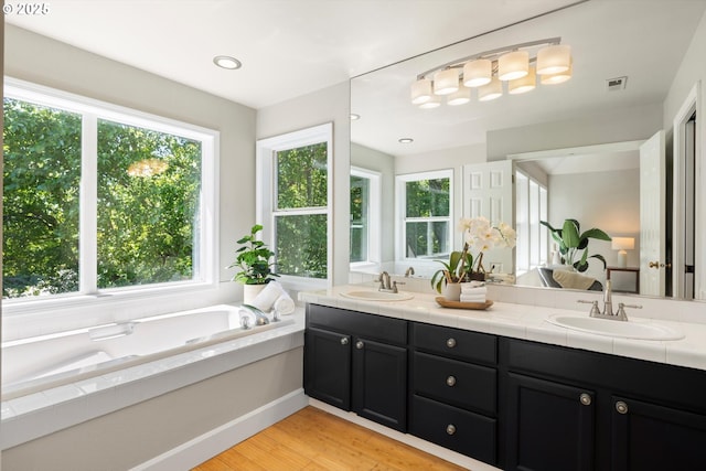 4698 Winthrop Ct, Lake Oswego, OR 97035 - bathroom with double vanity, a bath, and wood finished floors