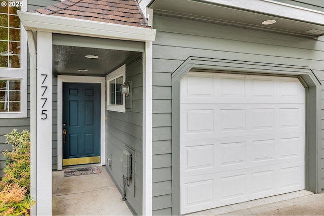 entrance to property featuring roof with shingles