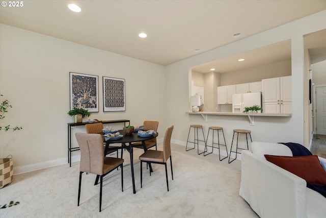 dining room featuring light colored carpet, recessed lighting, and baseboards