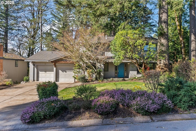 view of front of property featuring concrete driveway and a garage