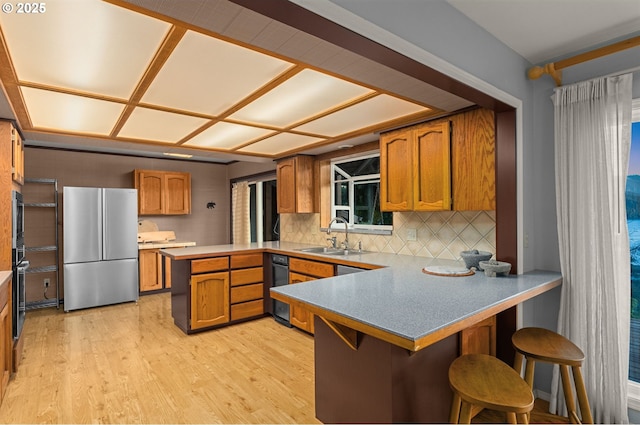 142 Lyons Rd, Stevenson, WA 98648 - kitchen with stainless steel appliances, a peninsula, a sink, and brown cabinetry