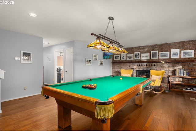 142 Lyons Rd, Stevenson, WA 98648 - rec room featuring baseboards, wood finished floors, billiards table, a brick fireplace, and brick wall