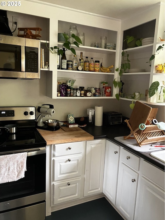 kitchen with open shelves, appliances with stainless steel finishes, and white cabinets