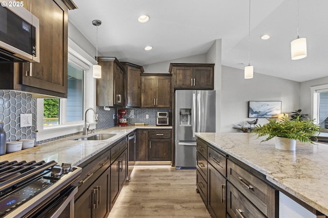 4635 Chaucer Ct, Depoe Bay, OR 97341 - kitchen with appliances with stainless steel finishes, vaulted ceiling, dark brown cabinetry, plenty of natural light, and light stone countertops