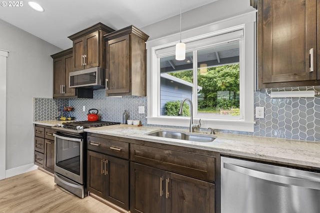4635 Chaucer Ct, Depoe Bay, OR 97341 - kitchen featuring appliances with stainless steel finishes, light stone countertops, backsplash, and pendant lighting