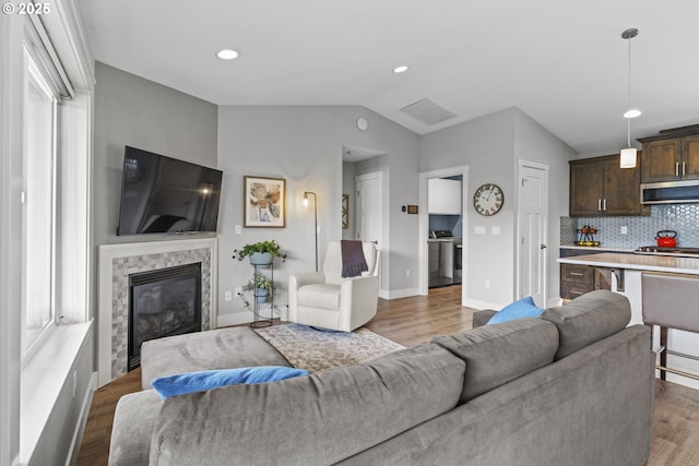 4635 Chaucer Ct, Depoe Bay, OR 97341 - living room featuring vaulted ceiling, wood finished floors, a glass covered fireplace, and recessed lighting