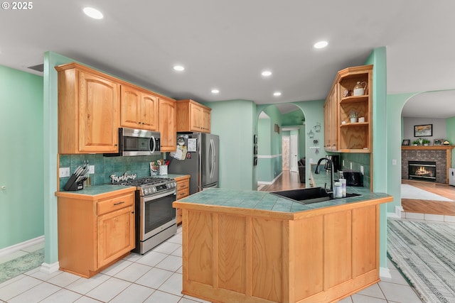 292 Jamie Loop, Roseburg, OR 97471 - kitchen with stainless steel appliances, a sink, arched walkways, tile counters, and open shelves